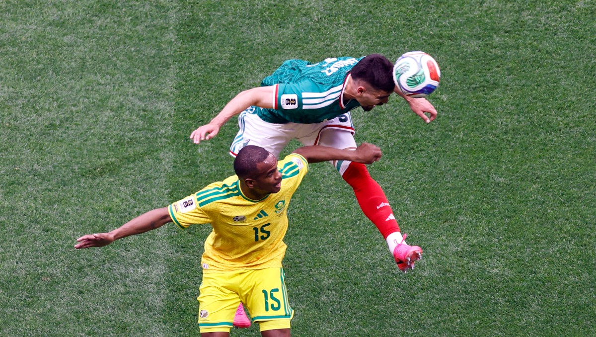 Johan Vázquez le gana el balón a Iqraam Rayners en el México vs Sudáfrica