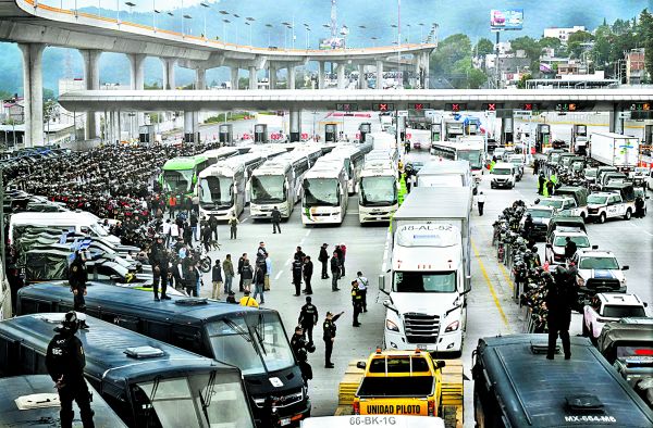 Policías cierran paso a autobuses de la Normal de Ayotzinapa en la México-Cuernavaca. AFP
