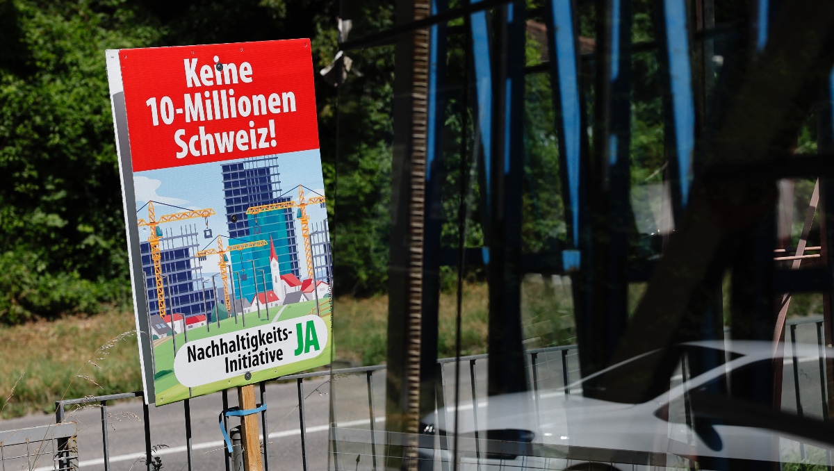 Cartel electoral con el lema "No a una Suiza de 10 millones" mientras los suizos votan sobre una polémica propuesta antimigración. | AFP