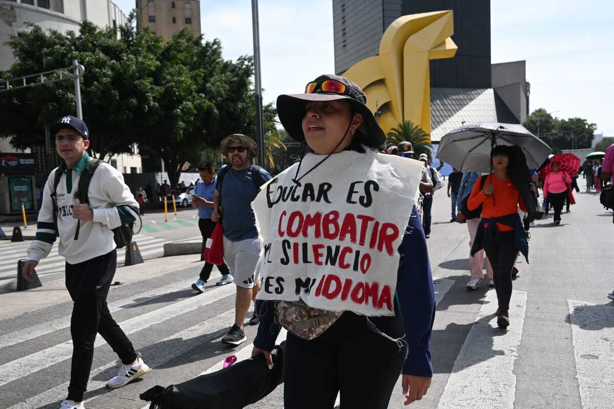 Integrante de la CNTE marcha con manta de protesta en Paseo de la Reforma, CdMx. | Foto: Daniel Augusto