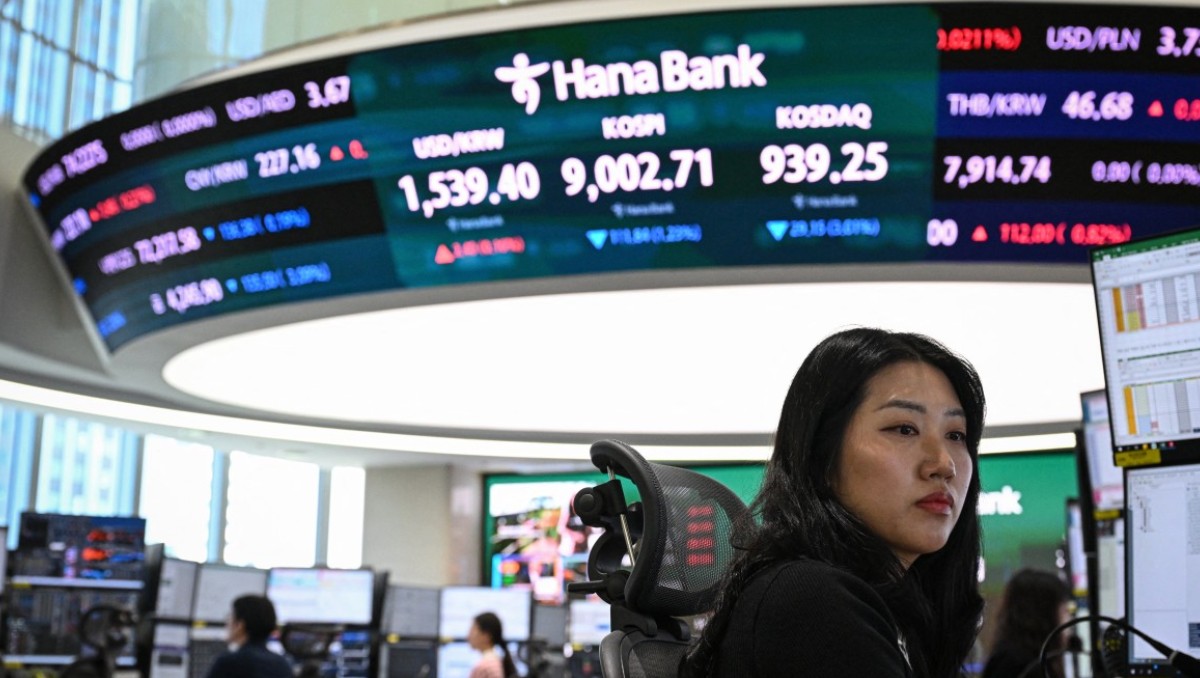 Operadores de divisas monitorean los tipos de cambio mientras se muestra el índice bursátil de referencia de Corea. | Foto: AFP