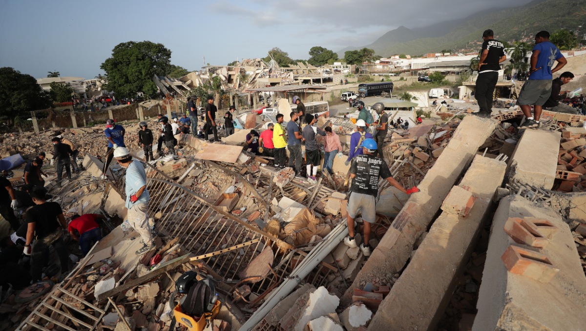 Personas realizan labores de búsqueda en una zona afectada por un terremoto, este viernes en La Guaira | EFE