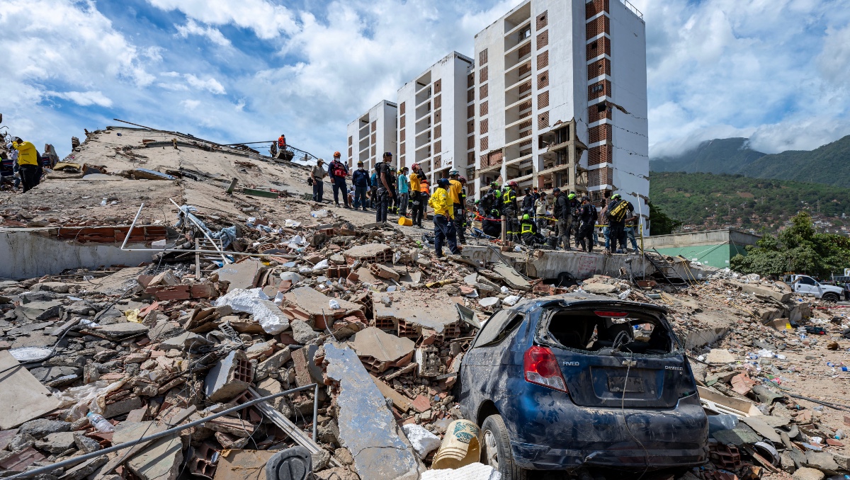 Voluntarios y residentes buscan sobrevivientes entre los escombros de edificios colapsados en Caraballeda, La Guaira. | AFP
