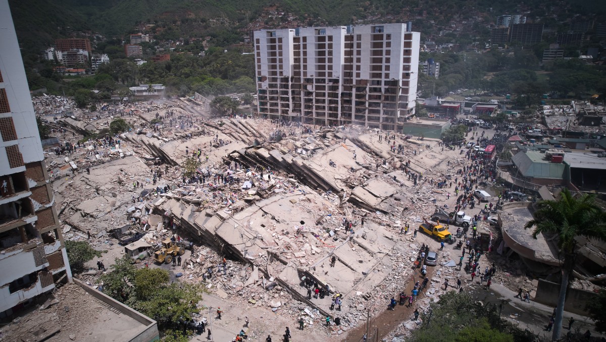Residentes y rescatistas buscan entre los escombros dos días después de un terremoto, el viernes 26 de junio de 2026, en La Guaira. | AP