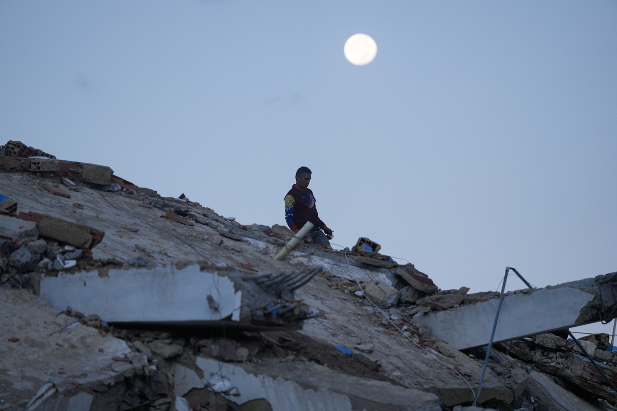 Un hombre camina entre los escombros de un edificio que se derrumbó durante los terremotos en La Guaira. | Foto: AP