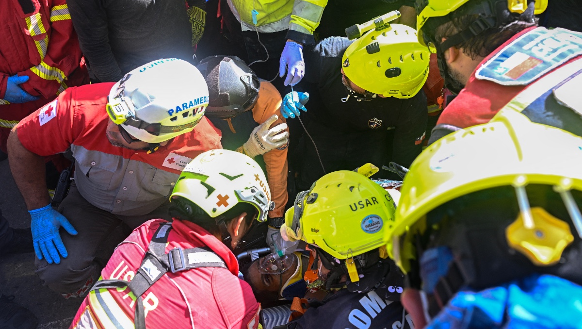 Equipo de rescate internacional ayuda a Hernán Gil, superviviente de los terremotos gemelos de Venezuela, en Catia La Mar, estado de La Guaira. | AFP