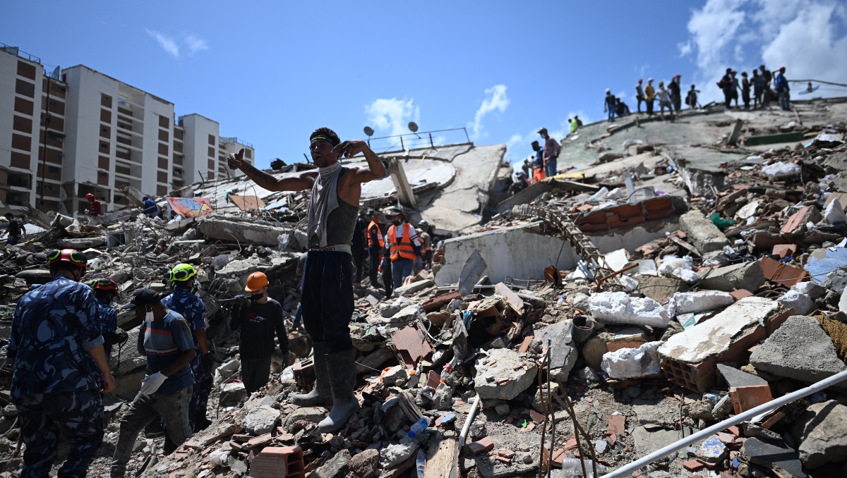 Familiar de las víctimas gesticula mientras grita, mientras los equipos de rescate y voluntarios trabajan La Guaira. | AFP