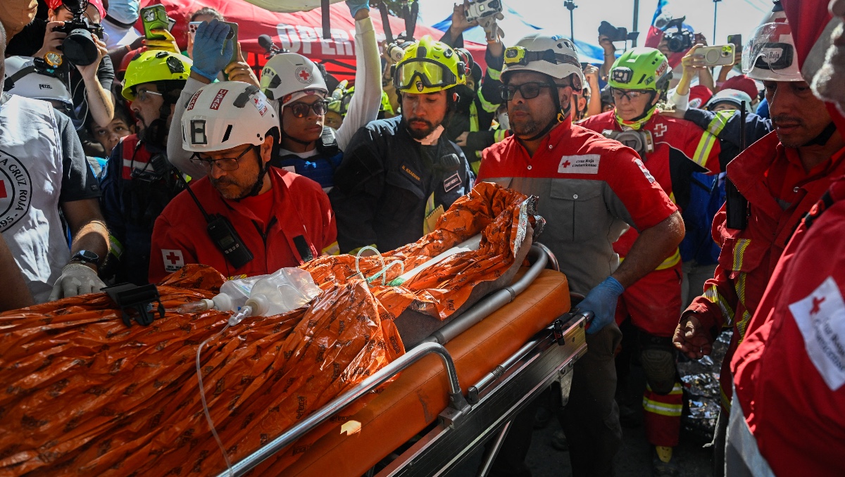 Equipo de rescate internacional traslada a Hernán Gil, superviviente de los terremotos gemelos de Venezuela, a una ambulancia en Catia La Mar. | AFP