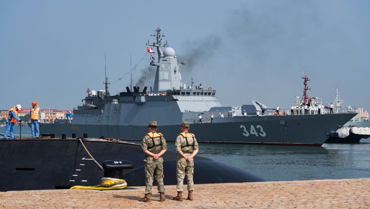Soldados chinos hacen guardia mientras la corbeta rusa Rezky llega a un puerto militar en Qingdao. | AP