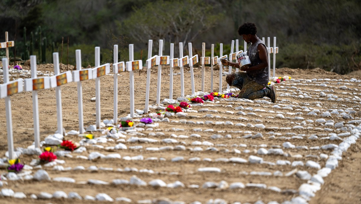 Trabajador pinta las tumbas de víctimas no identificadas del terremoto en el cementerio La Esperanza, en Catia La Mar. | AFP