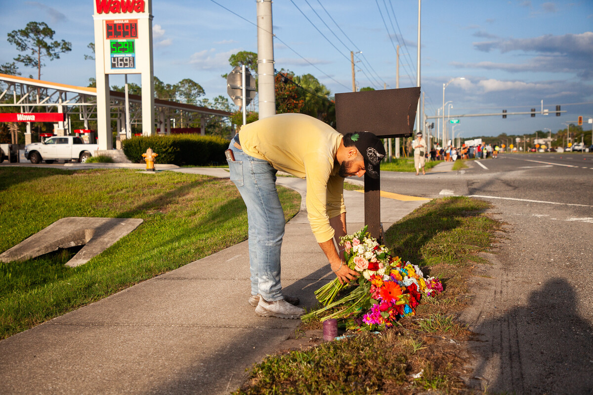 Edgar Olalde, de Jacksonville, que conocía a la víctima gracias a su tienda, deposita ramo de flores durante una vigilia en honor al falllecido. |  AP