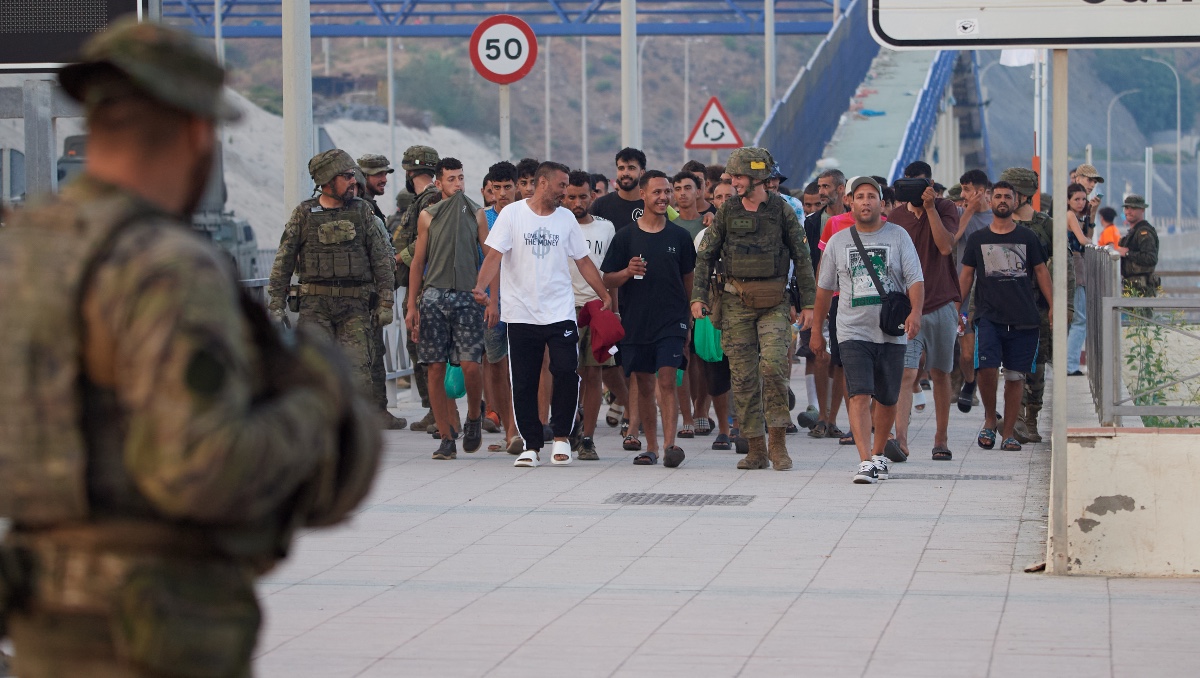 Militares españoles escoltan a migrantes que cruzaron a España de regreso a Marruecos desde el enclave español de Ceuta. | AP