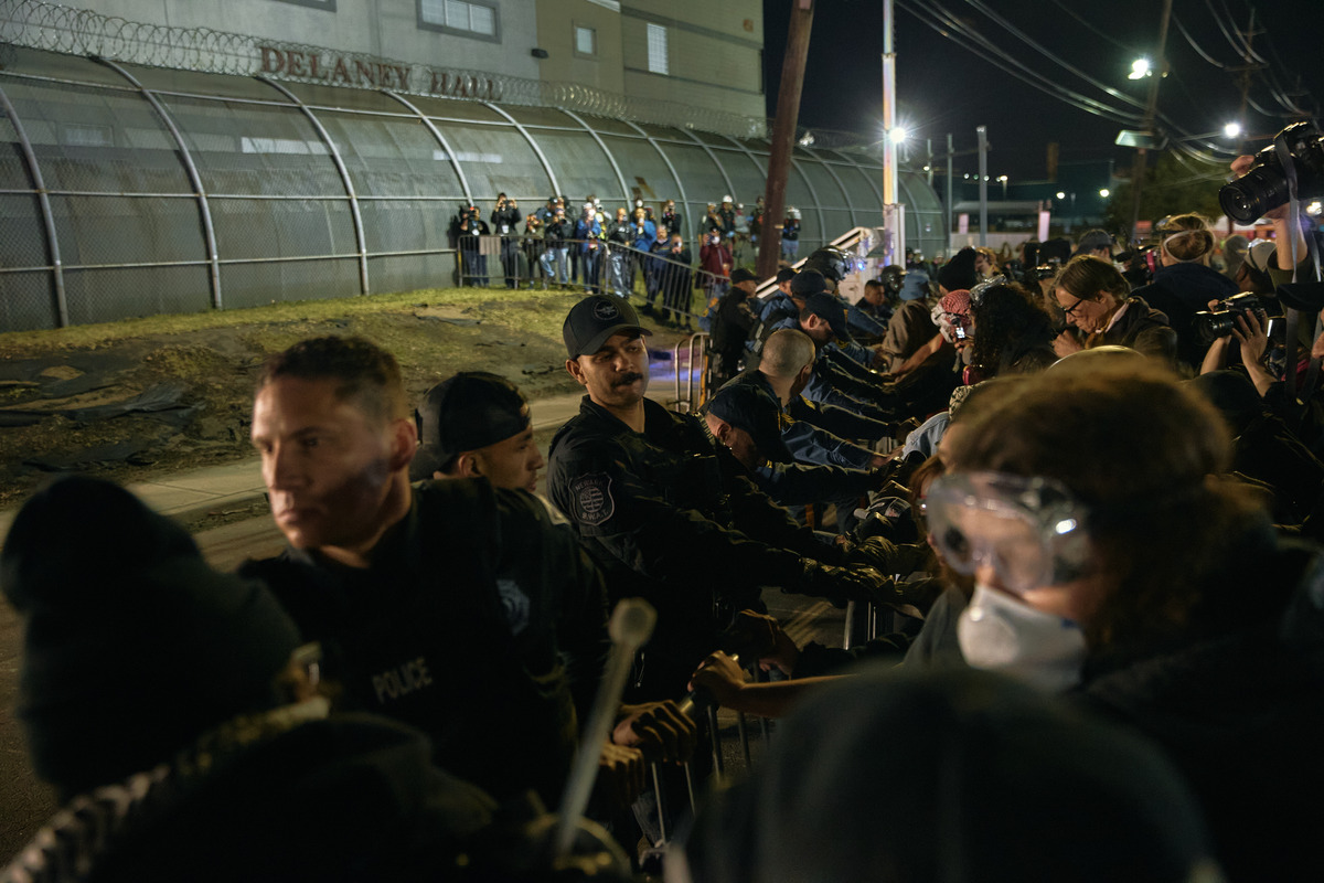 La policía intenta contener a los manifestantes que empujan las vallas frente al centro de detención Delaney Hall. | AP