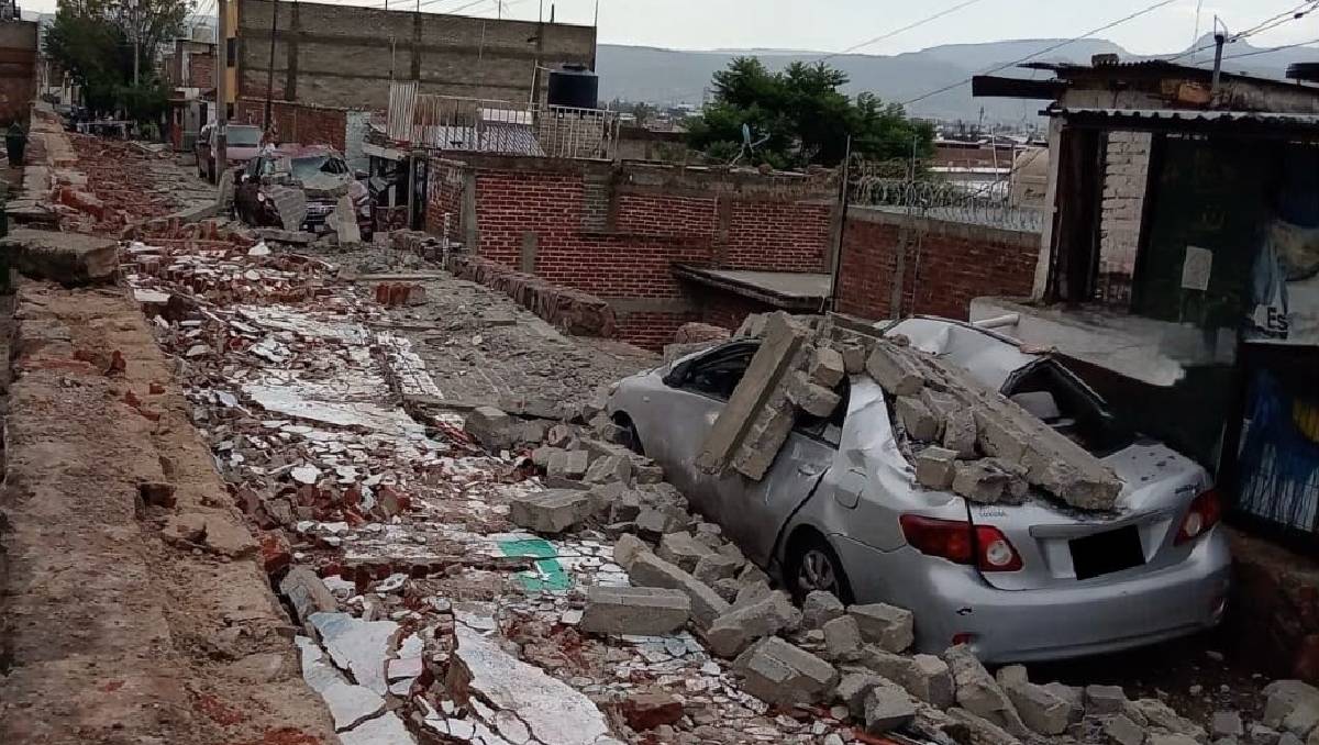 El derrumbe de la barda causó afectaciones en vehículos estacionados cerca del inmueble | Redes sociales