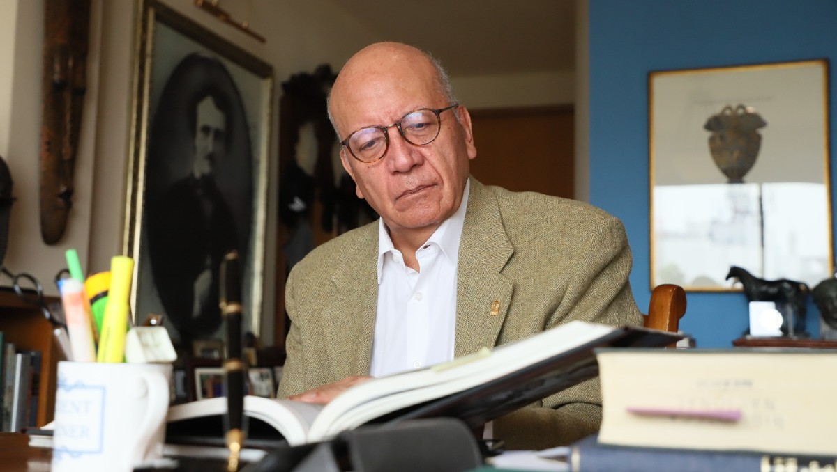 El autor en su departamento en 2025, rodeado de libros, obras de arte, recuerdos y Edgar Allan Poe. Foto: Octavio Hoyos