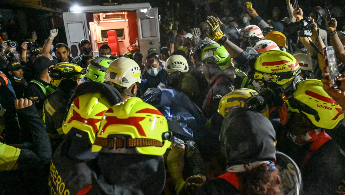 Bomberos y equipos de rescate sacan a la superviviente Daniela Andrea Largo Sánchez de entre los escombros de un edificio colapsado. | AFP