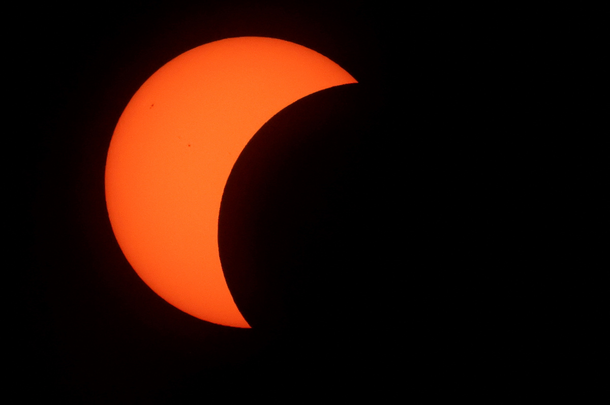 Primeras fases del eclipse solar total, desde la playa de La Zurriola en San Sebastián | AFP