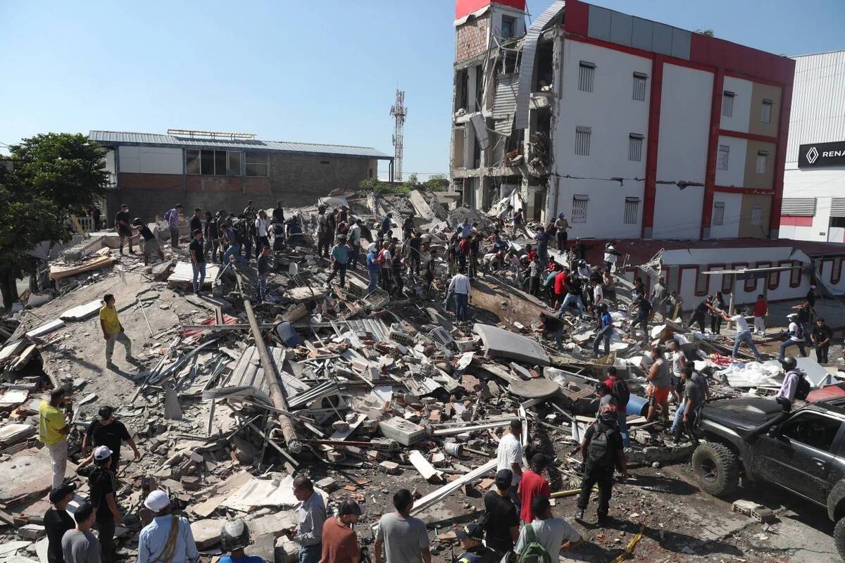 Residentes y rescatistas buscan entre los escombros de un edificio derrumbado tras un sismo ocurrido en Cali. | Foto: AP