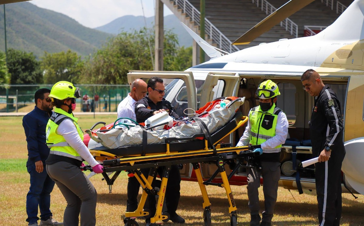 Personal médico realiza el traslado del menor desde la ambulancia aérea.