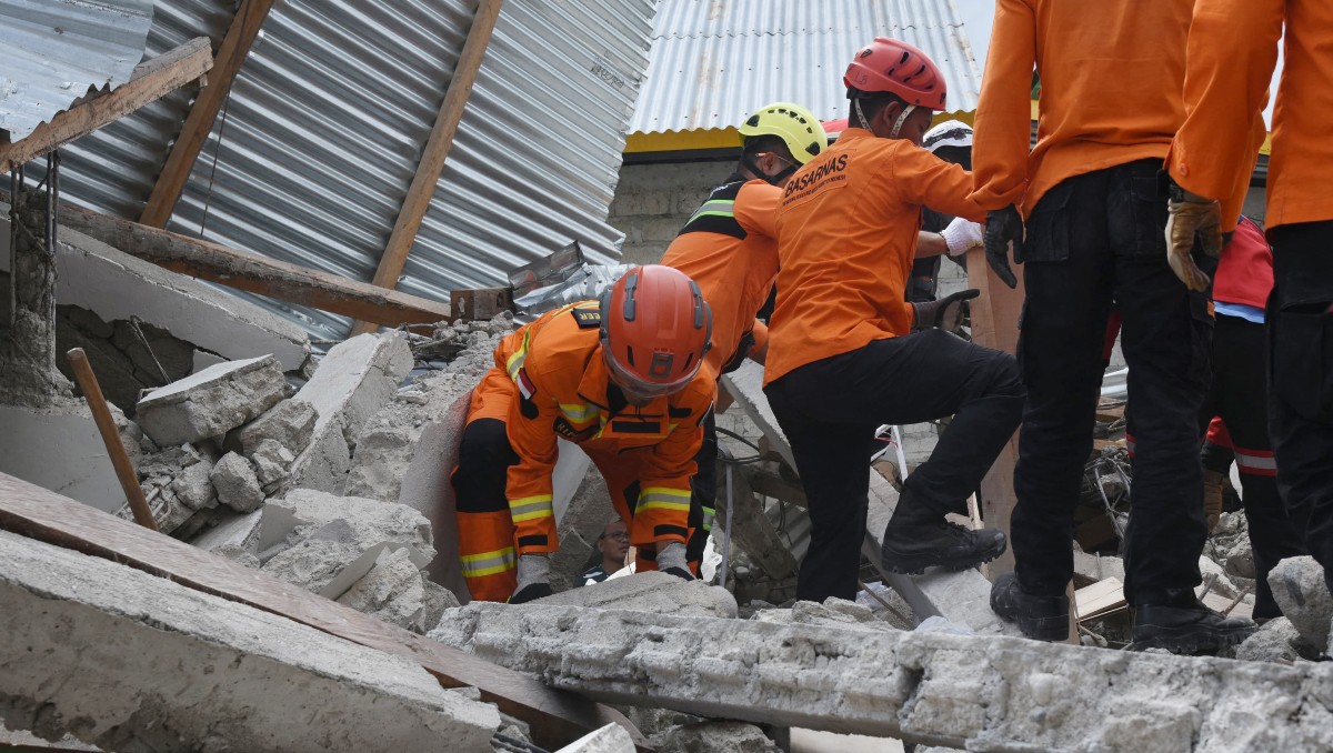 Personal de rescate trabajando en el lugar donde se derrumbó un edificio en Indonesia. | AFP