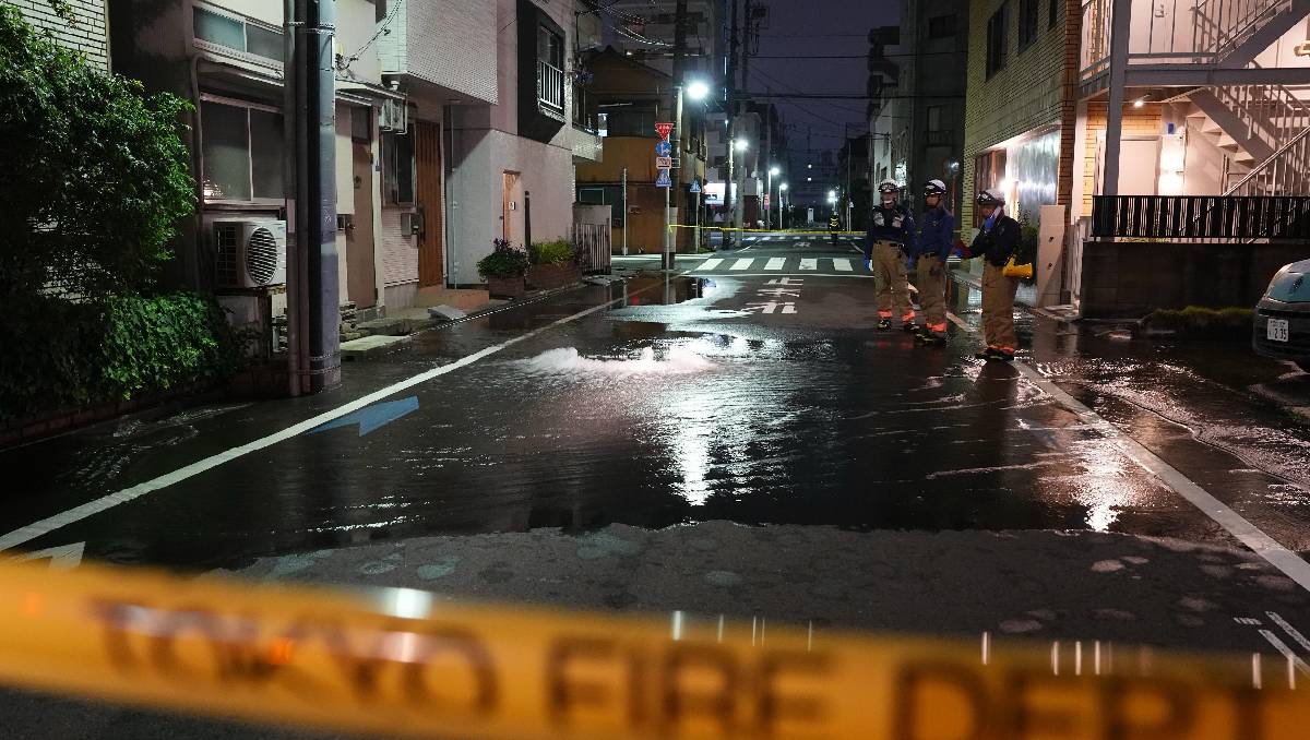 Rescatistas del Departamento de Bomberos de Tokio junto a un camino parcialmente inundado. | Foto: AP