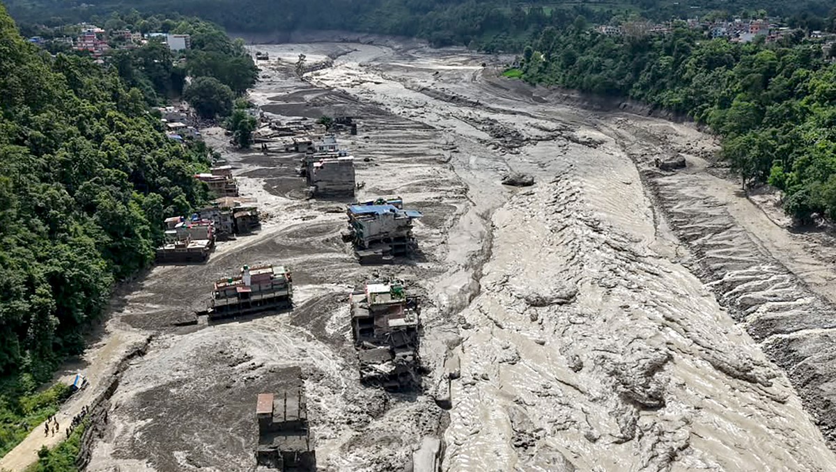 Casas yacen parcialmente sumergidas en aguas fangosas a orillas de un río tras unas inundaciones repentinas en Trishuli Bazar. | AFP