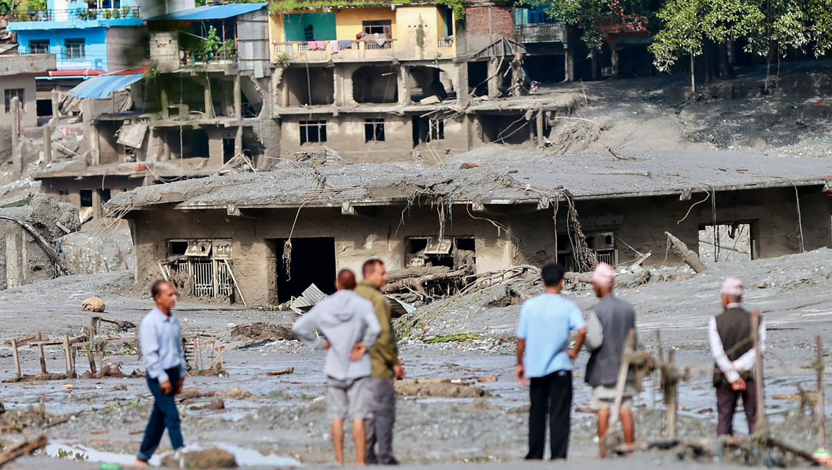 Residentes locales inspeccionan casas anegadas por el lodo tras las inundaciones repentinas en Devighat | Foto: AFP