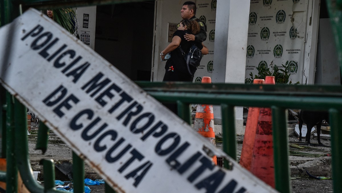 Miembros de la Policía Nacional de Colombia reaccionan tras la explosión de un coche bomba cerca de una comisaría en Los Patios. | AFP