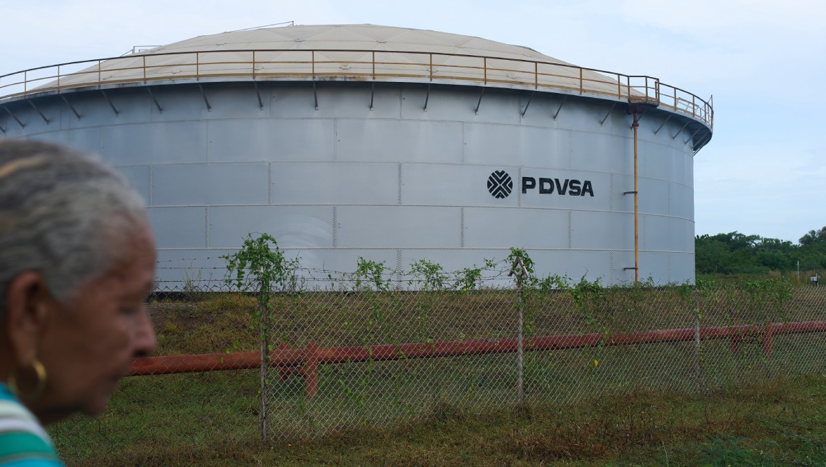 Mujer pasa junto a un tanque de almacenaje de la petrolera estatal venezolana, PDVSA, en Cabimas, Venezuela. Septiembre de 2026. | Foto: AP
