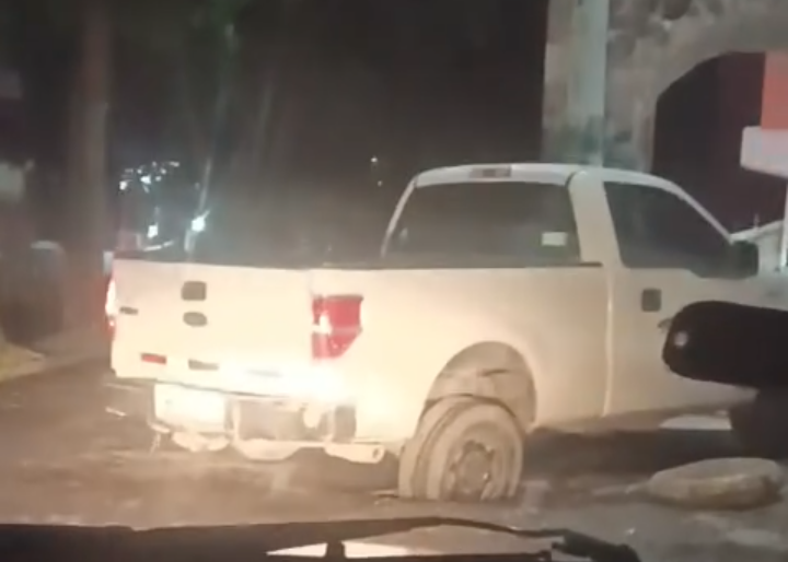 Camioneta queda atorada en coladera. (Cortesía)