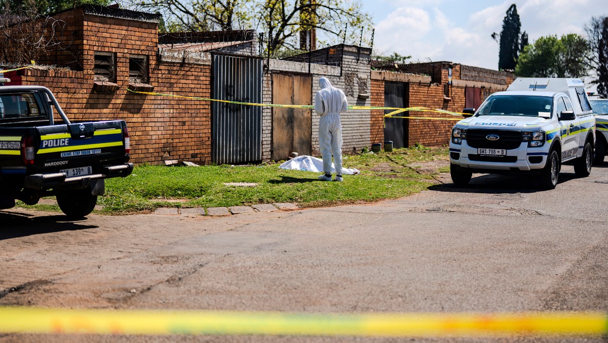 Un forense trabaja en la escena donde se encontró el cuerpo de una mujer en una carretera en KwaThema, Springs, Sudáfrica. | AP