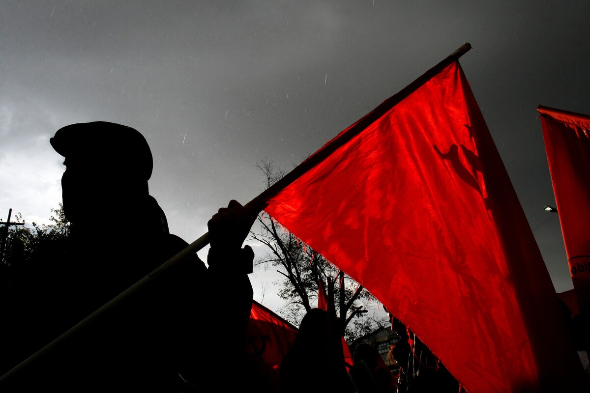 'Rojinegro'. Un manifestante con una bandera del Partido Comunista espera para impedir el paso a la toma de posesión de Felipe Calderón. Octavio Hoyos