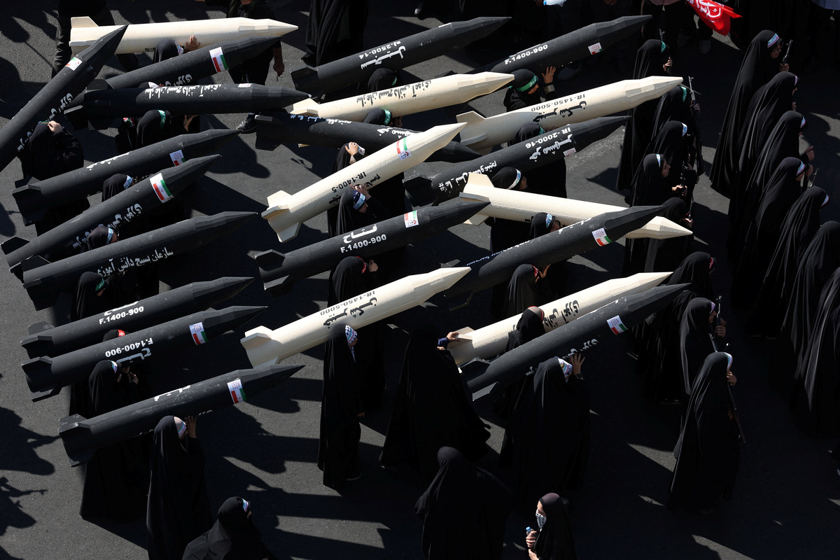 Mujeres integrantes de las fuerzas de la milicia iraní (Basij) portan maquetas de misiles durante un desfile militar en Teherán, Irán. | Reuters