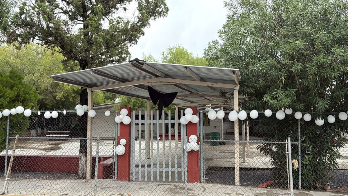Desde al exterior de la Escuela Primaria Elvira Rodríguez Garza fueron colocados globos blancos y un moño negro. Édgar Plata