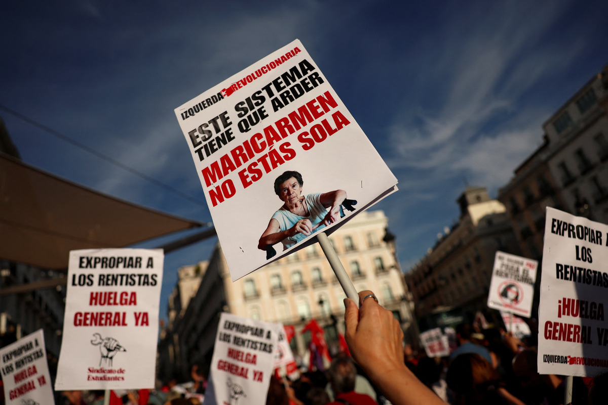 Cartel con el mensaje "Este sistema debe arder. Maricarmen, no estás sola" durante una protesta contra la crisis de la vivienda en España. | Reuters