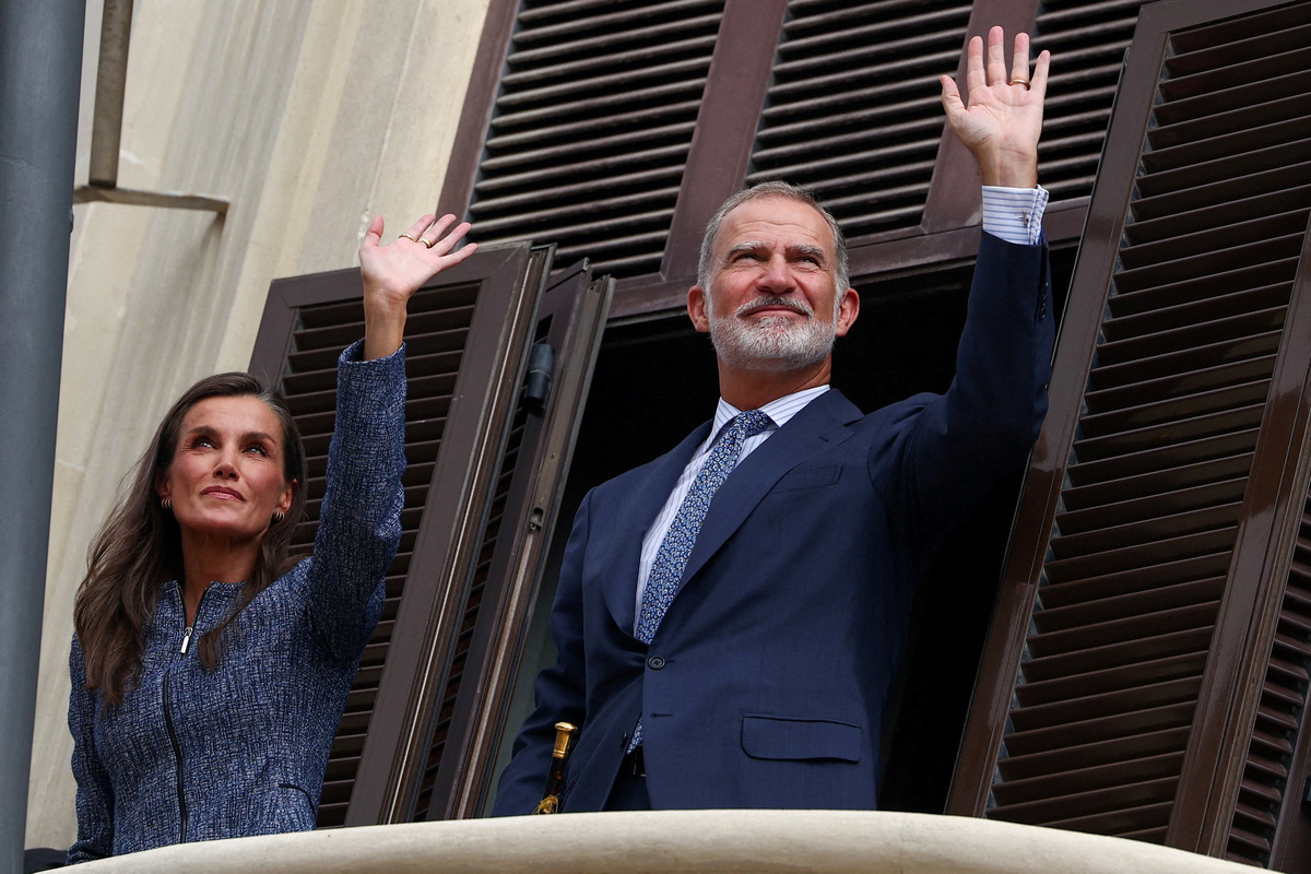 Los reyes de España, Felipe y Letizia, saludan a la gente desde un balcón durante su visita a Ceuta, España. | Reuters