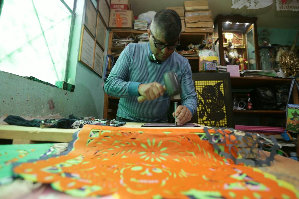 El artesano Sergio Alejandro Hernández realiza el trazado y cincelado manual de papel picado en su taller de Metepec | Foto: Tania Contreras
