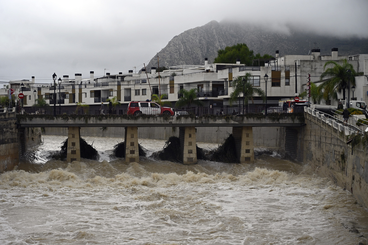 Puente que cruza el río Girona, el cual presenta un caudal desbordado tras unas lluvias torrenciales en España. | AFP