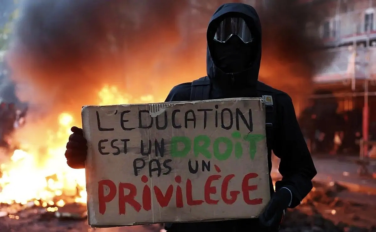 Manifestante sostiene un cartel con el mensaje: “La educación es un derecho, no un privilegio” durante las recientes protestas en Francia. (Reuters)