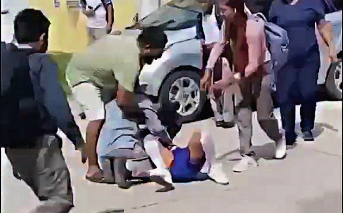 Un hombre intenta separar a dos estudiantes durante una pelea en Tampico. | Redes sociales