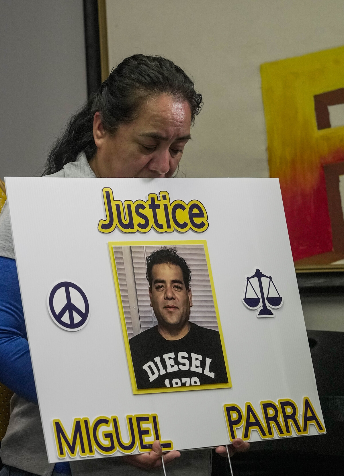 Carmen, hermana de Miguel Parra Hernández, sostiene un cartel en una conferencia de prensa. | AP